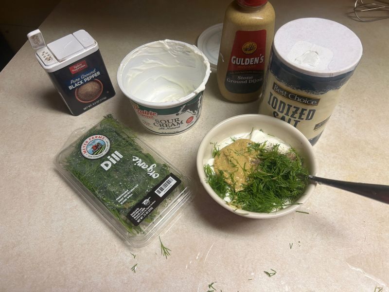 Mixing sour cream, Dijon mustard and dill for baked cod