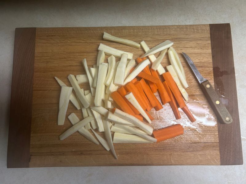Vegetable strips prepared for air frying on a cutting board