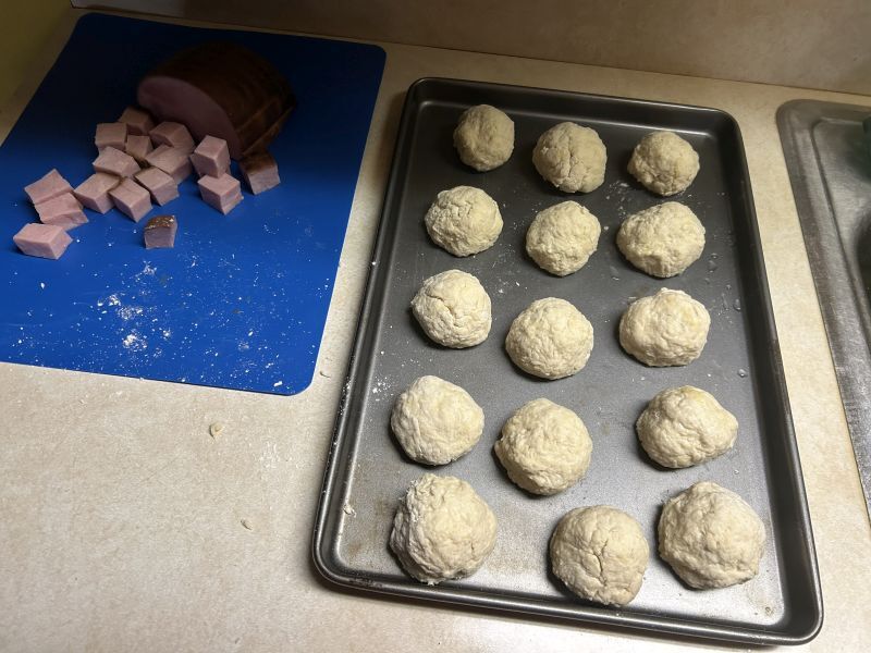 Forming Klubb dough around ham chunks before boiling