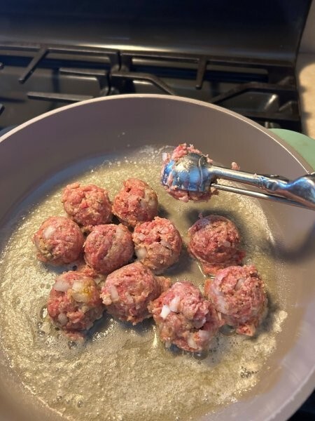 Scooping meatball mixture with a cookie scoop