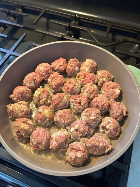 Meatballs frying in butter until golden brown