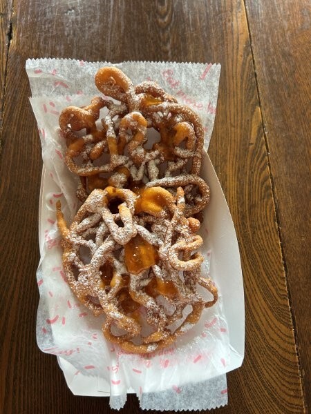 Funnel cakes ready to serve with powdered sugar and drizzle