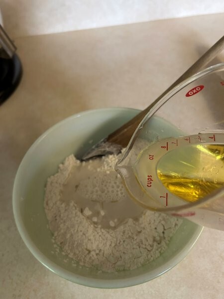 Making rosemary flatbread—a well in the flour mixture and pouring in the olive oil and water.