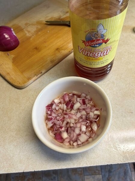 Red onion is chopped and marinating in red wine vinegar.