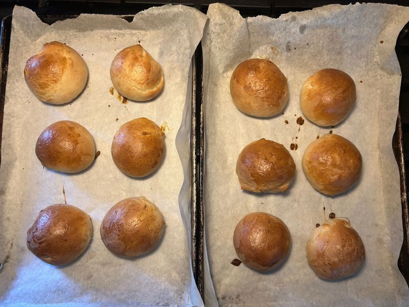Freshly baked golden Hveteboller buns cooling on tray
