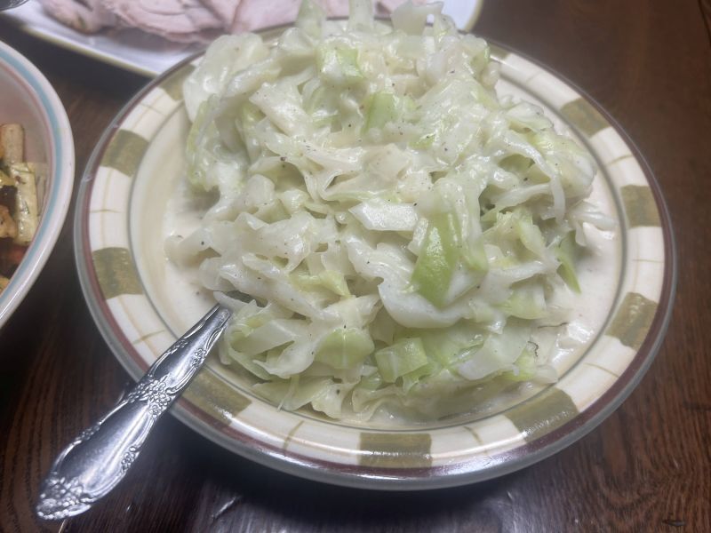 Kålstuing served over boiled potatoes with turkey on a Thanksgiving plate