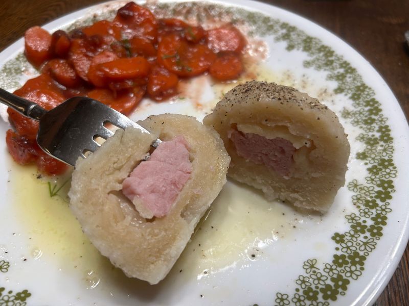 Close-up of a cooked Klubb dumpling with ham center, ready to serve