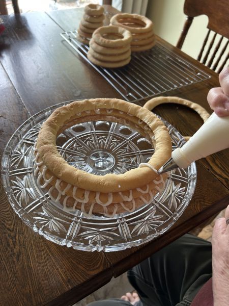Applying frosting to bottom ring of kransekake