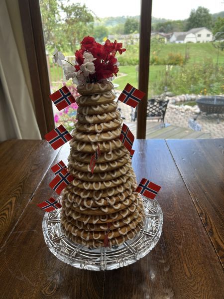 Finished kransekake decorated with faux flowers and Norwegian flags