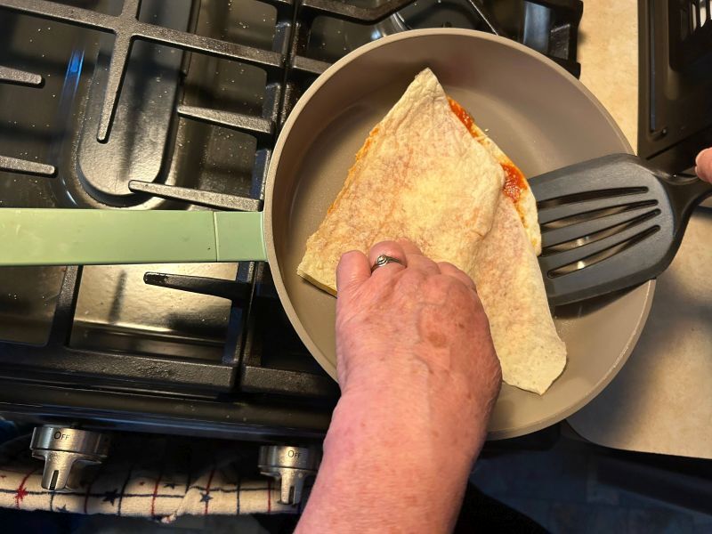 Cooking lefse pizza dippers in a skillet over medium heat