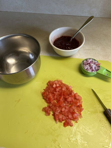 Chopped tomatoes and red onion for lingonberry salsa