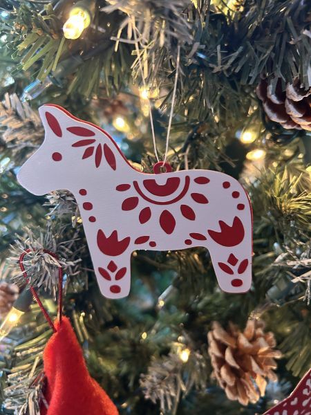 Close-up of a layered Norwegian Dala horse ornament on a Christmas tree.