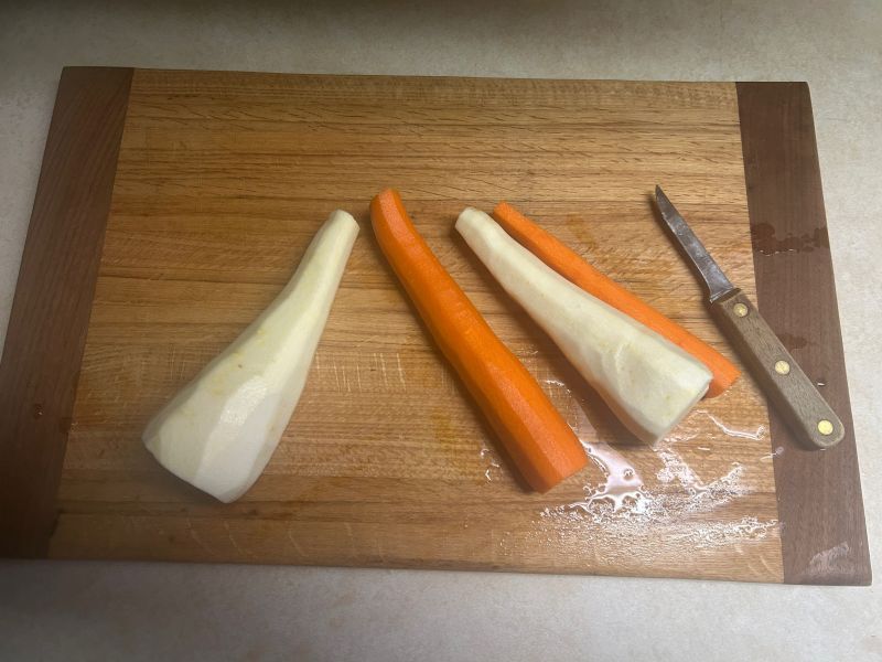 Fresh carrots and parsnips being peeled before cutting
