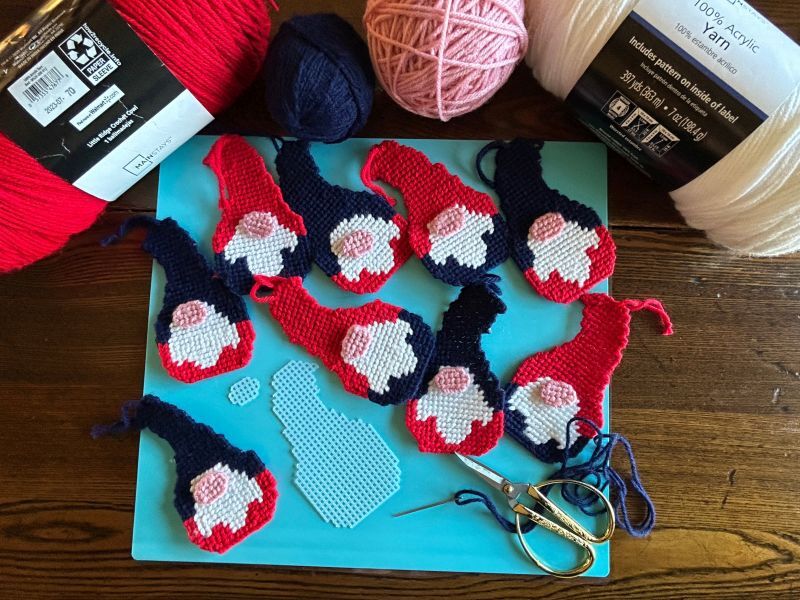Plastic canvas pieces cut and stitched with yarn to make a Scandinavian gnome ornament.