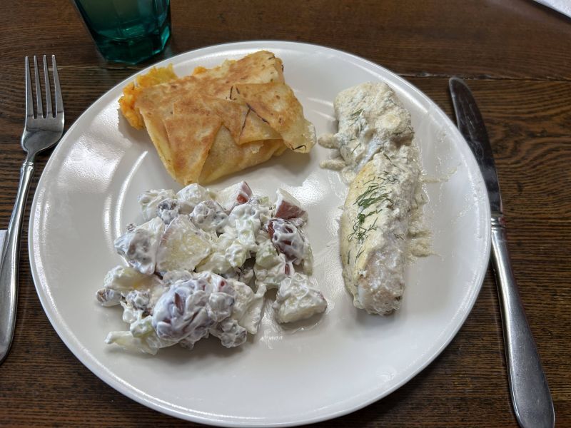 Plated January meal featuring creamy dill cod, Waldorf salad, and lefse vegetable mash wrap