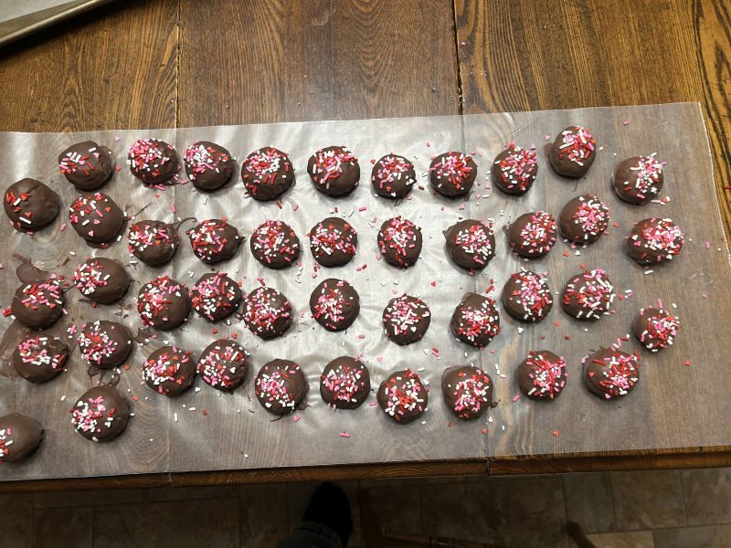 Dipping potato candy balls in chocolate
