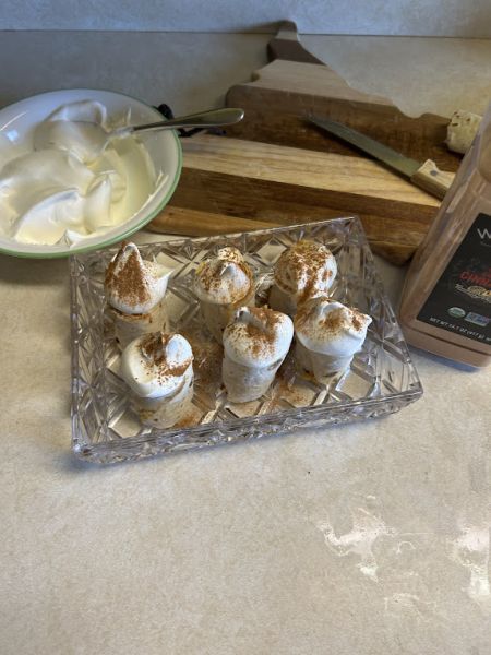 Sliced pumpkin lefse rolls with whipped cream and cinnamon.
