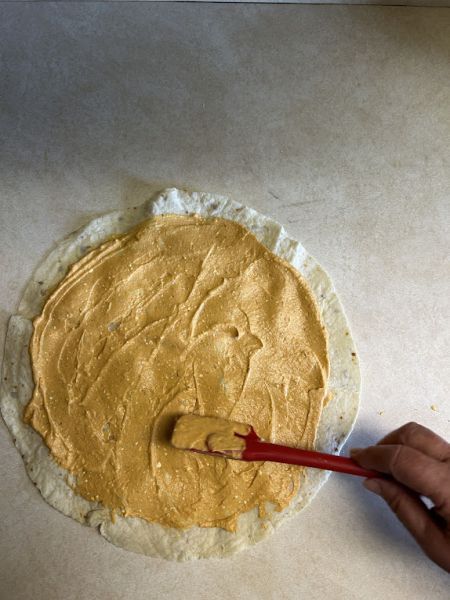 Pumpkin filling spread on a lefse sheet.