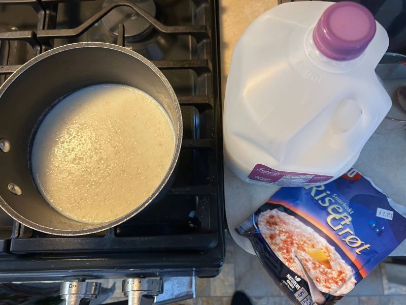 Adding milk to Risengr&oslash;t mix in a saucepan for Riskrem