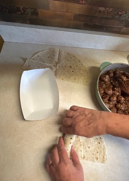 Lefse being wrapped around Norwegian meatballs