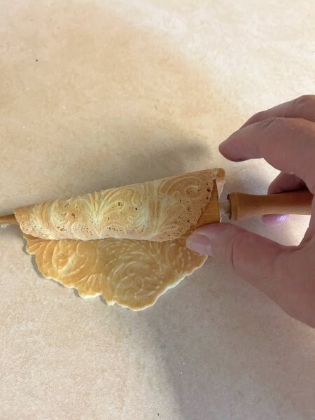 Rolling krumkake on wooden cone