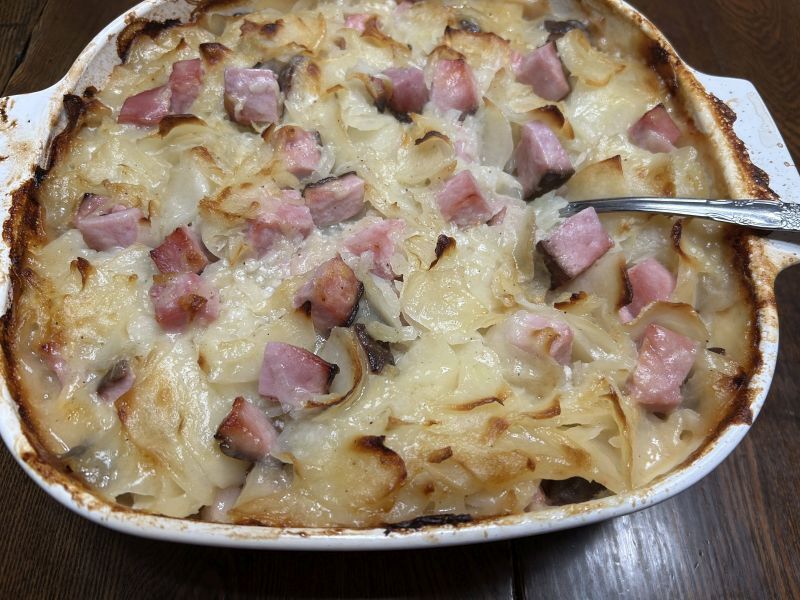 Golden baked scalloped potatoes with ham in a casserole dish, ready to serve for Christmas