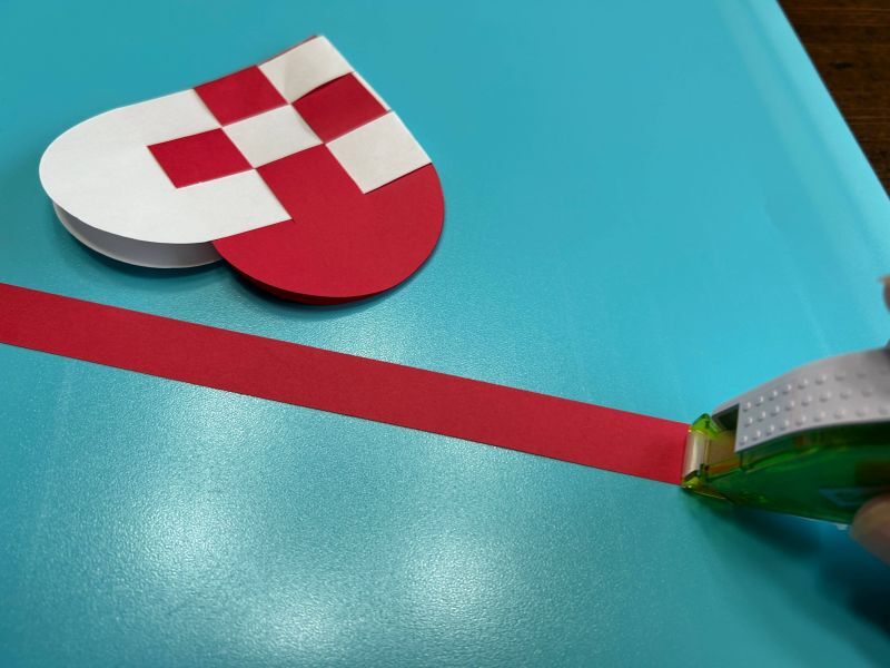 Handle strip being attached to the woven Scandinavian heart basket.