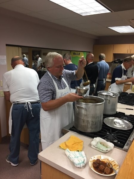 Steve Anderson fills a gravy bowl with meatballs in foreground