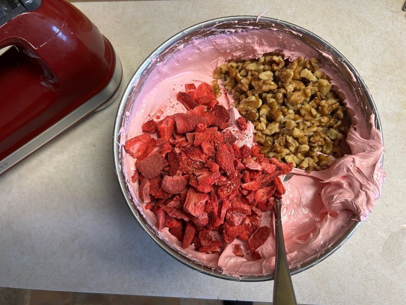 Adding nuts and strawberries to divinity mixture