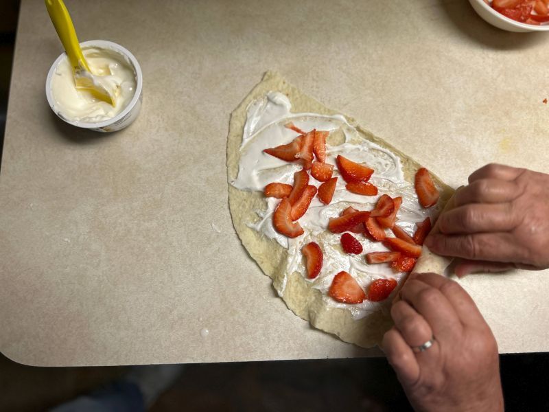 Rolling up the yogurt and strawberry filled lefse into a cylinder
